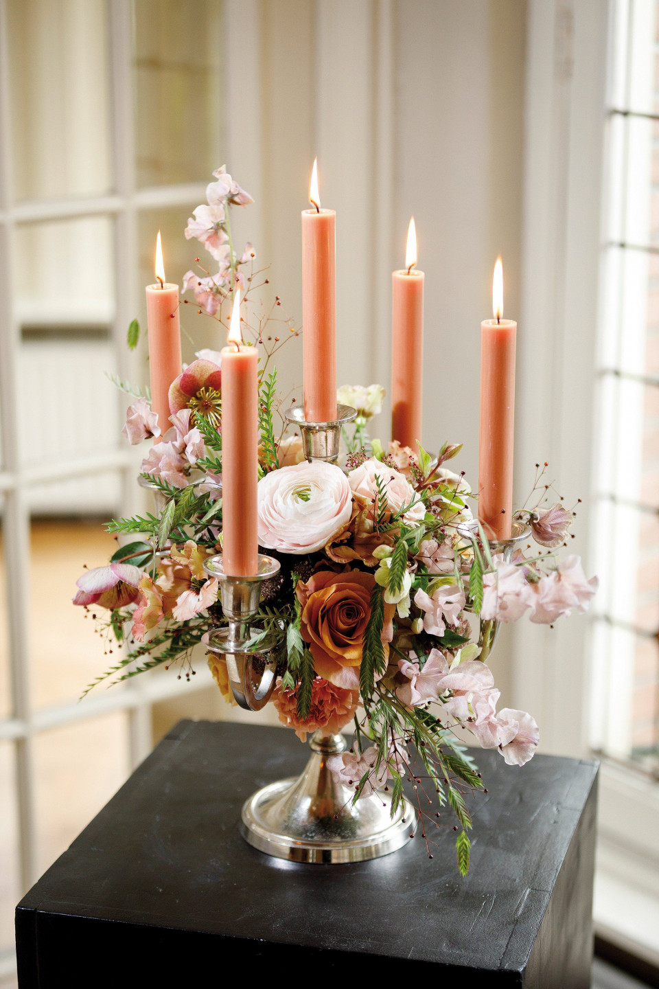 een bloemstuk met kaarsen op een tafel
