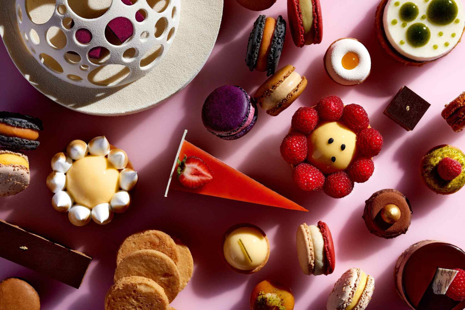 een verscheidenheid aan desserts zijn gerangschikt op een roze oppervlak