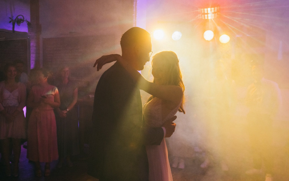 een bruid en bruidegom dansen voor een fel licht