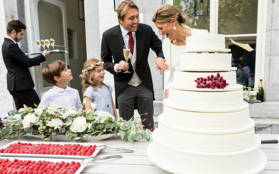 een man en vrouw die in een bruidstaart snijden