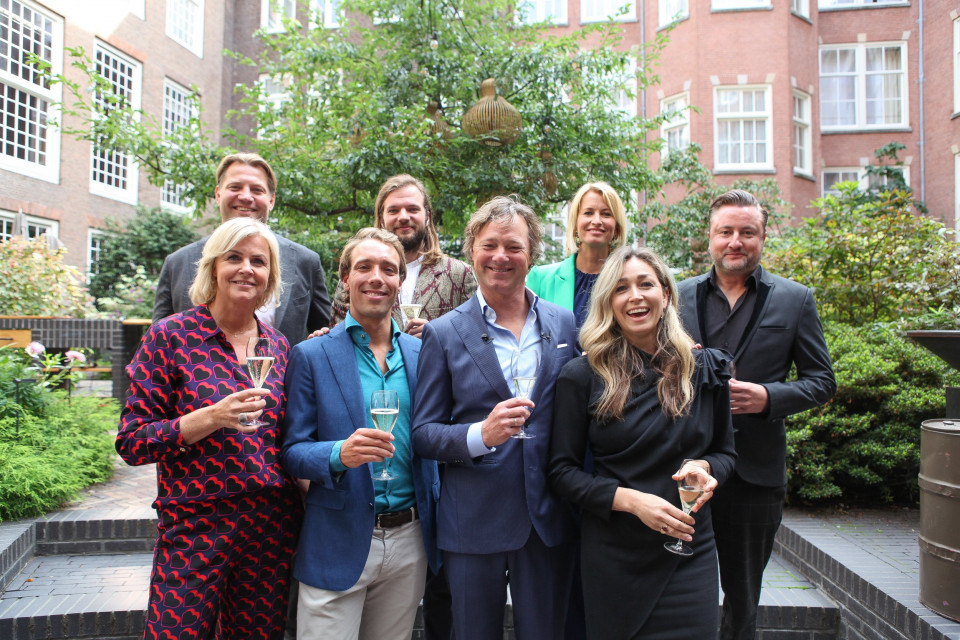 een groep mensen die poseren voor een foto met wijnglazen