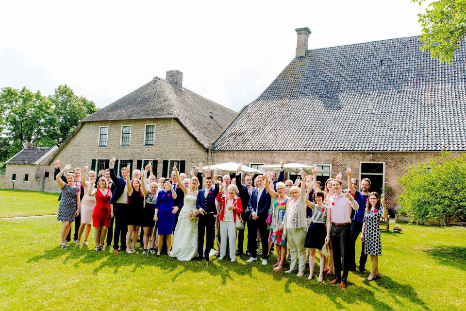 een groep mensen die poseren voor een foto voor een groot gebouw