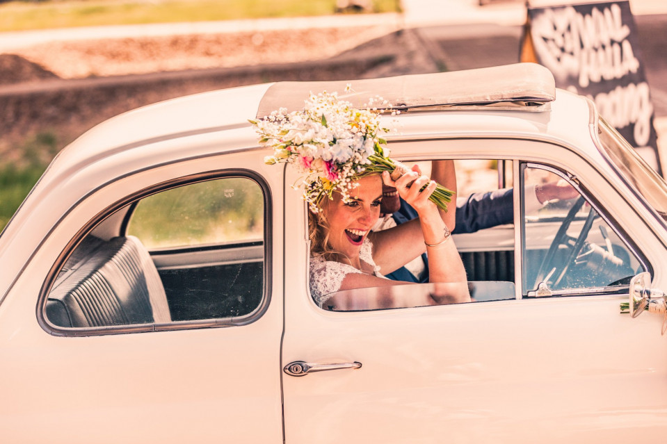 een bruid en bruidegom in een vintage auto