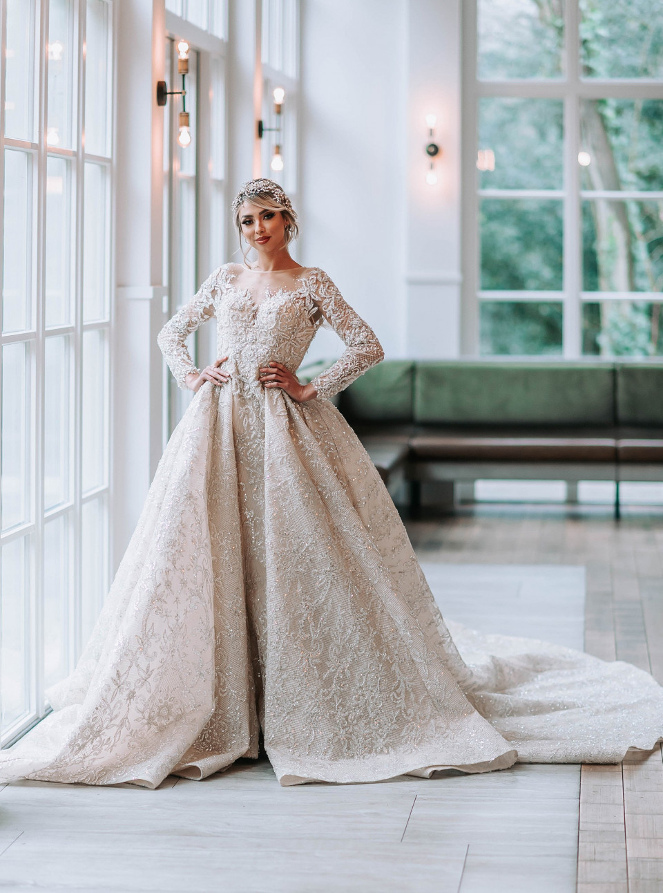 een bruid in een trouwjurk die poseert voor een raam