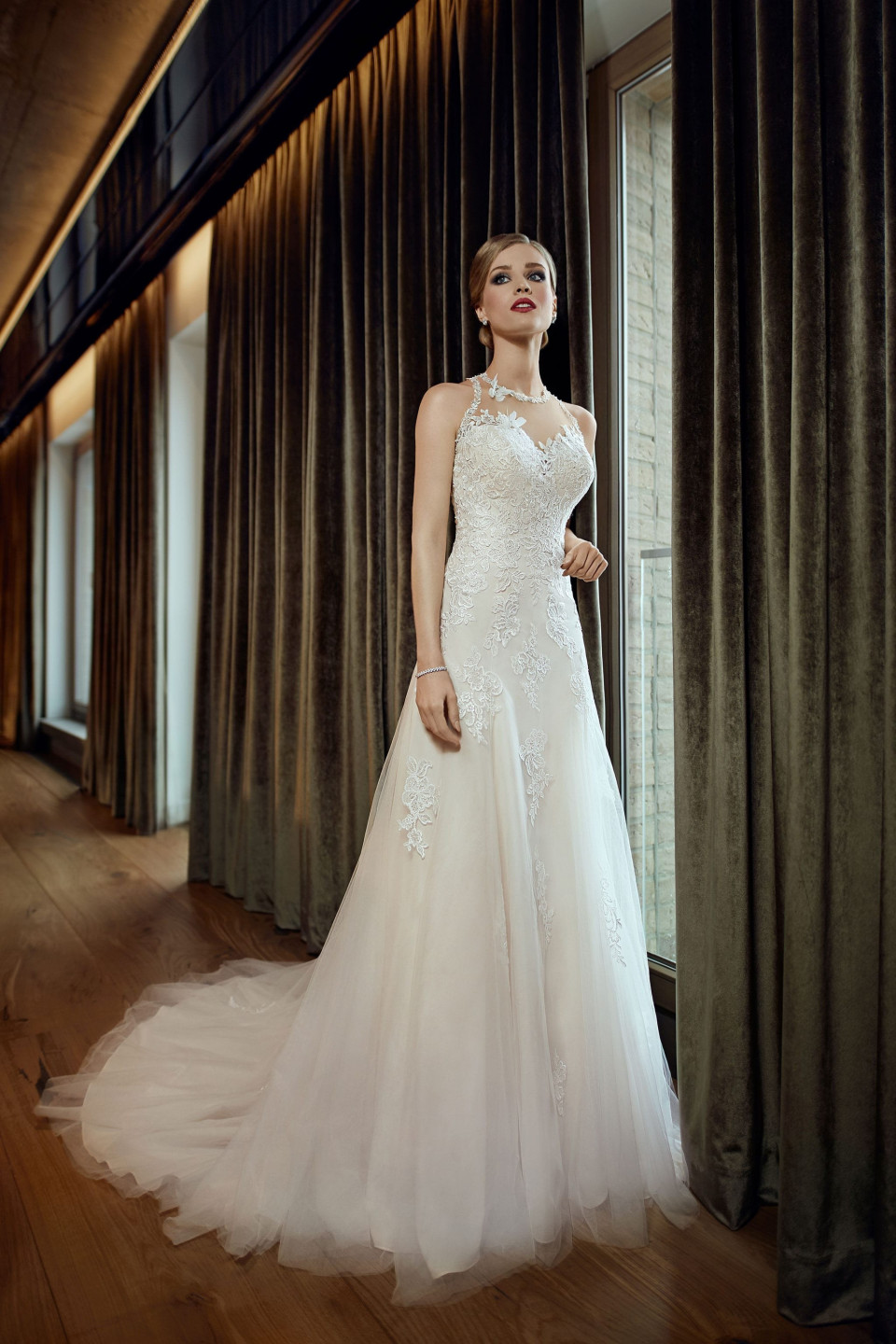 een vrouw in een trouwjurk staand voor een raam