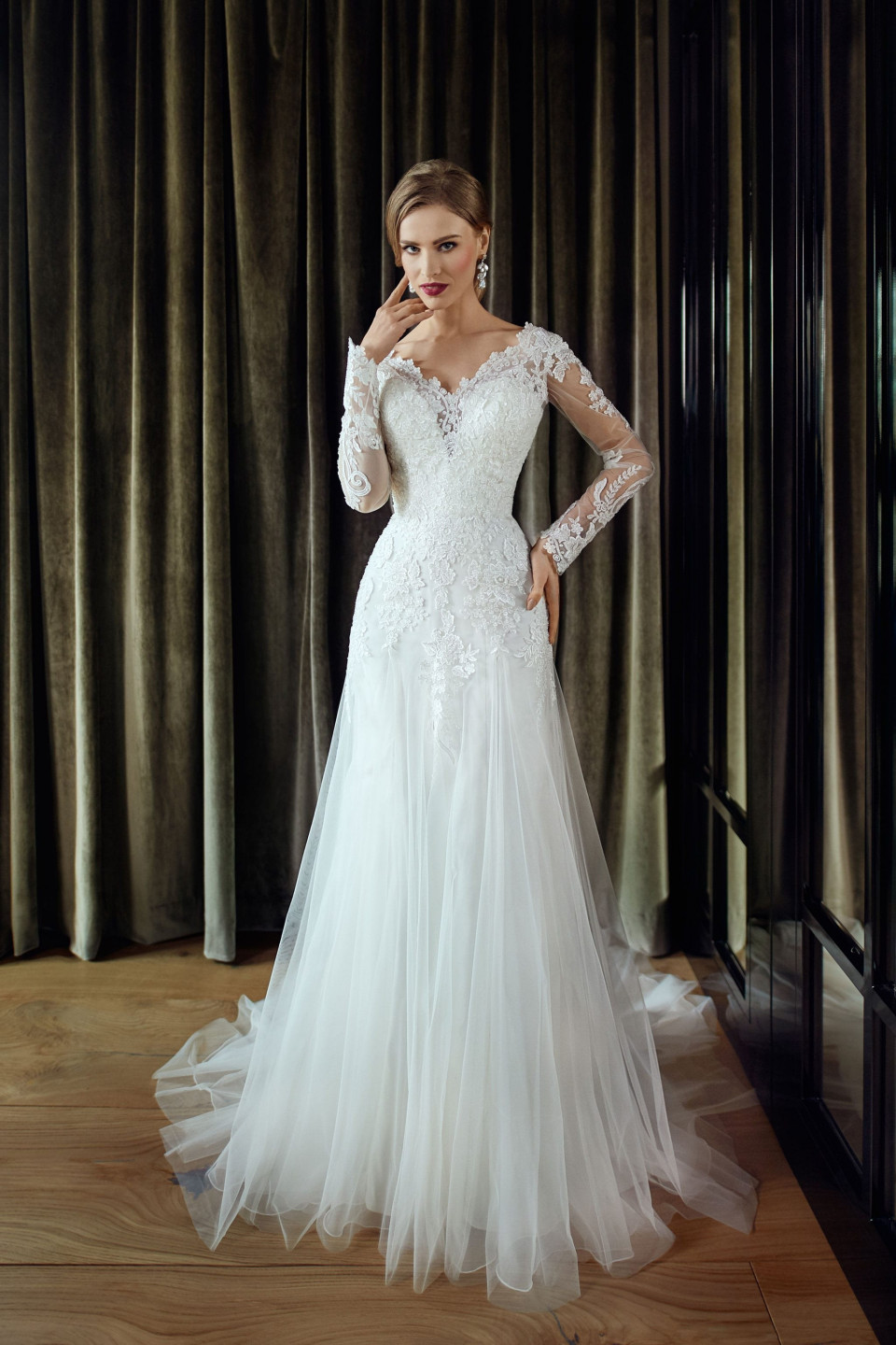 een mooie bruid in een lange mouwen trouwjurk