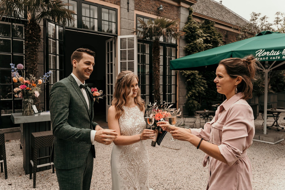een bruid en bruidegom die bloemen vasthouden terwijl het andere stel staat