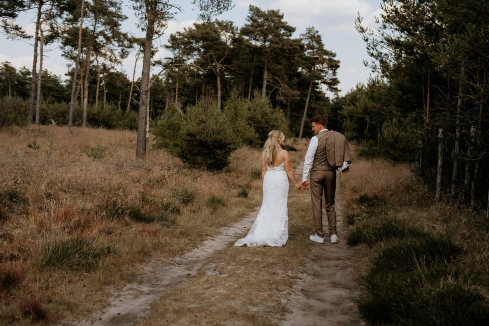een bruid en bruidegom lopen door het bos