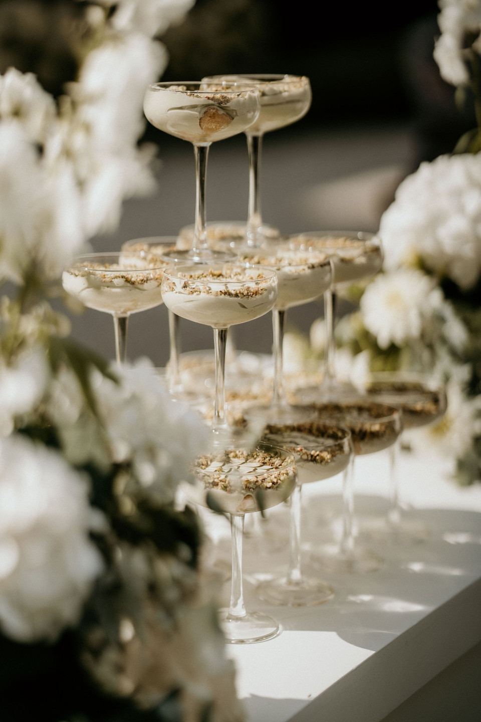 een stel desserts op een tafel met bloemen op de achtergrond