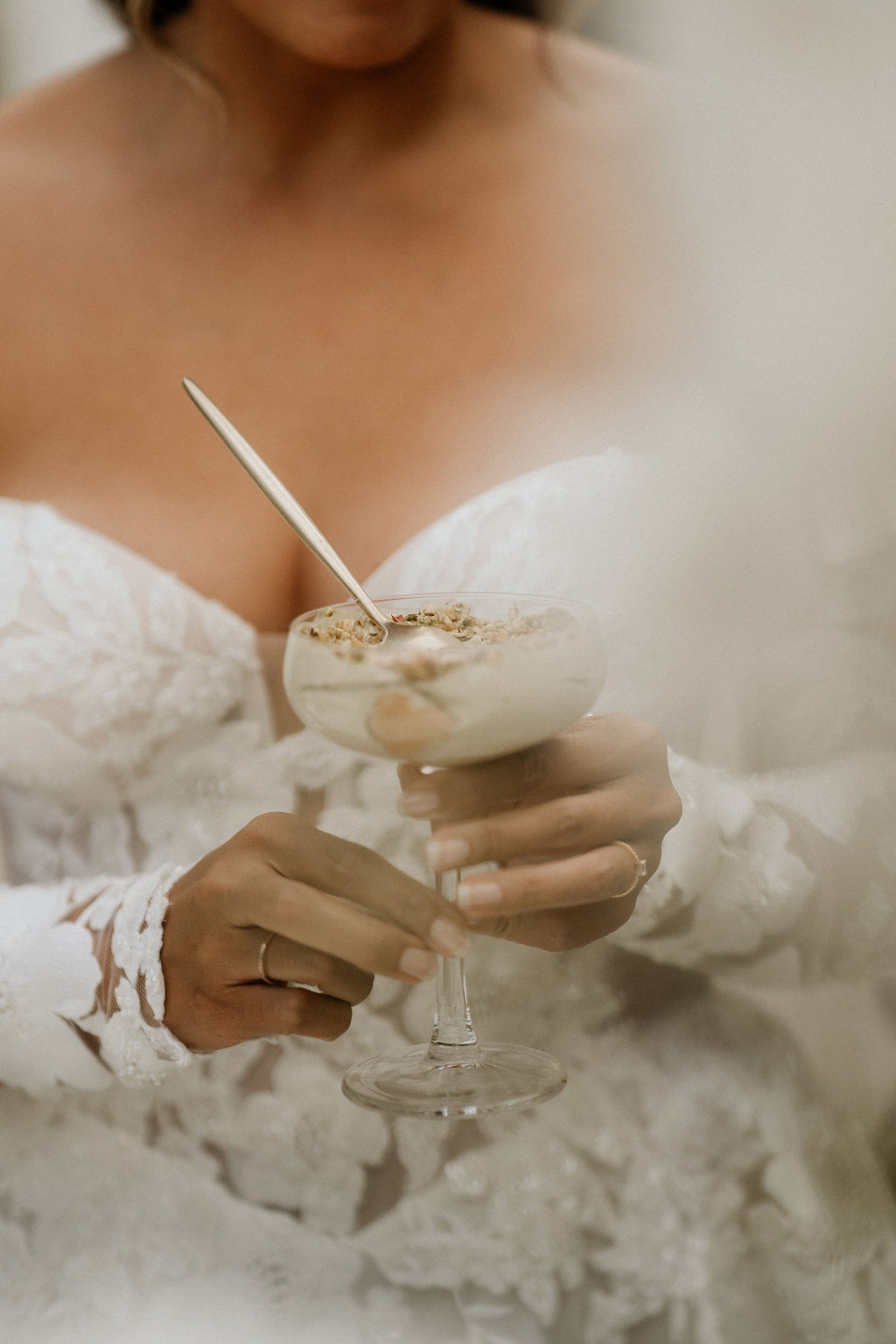 een vrouw in een trouwjurk die een glas ijs vasthoudt