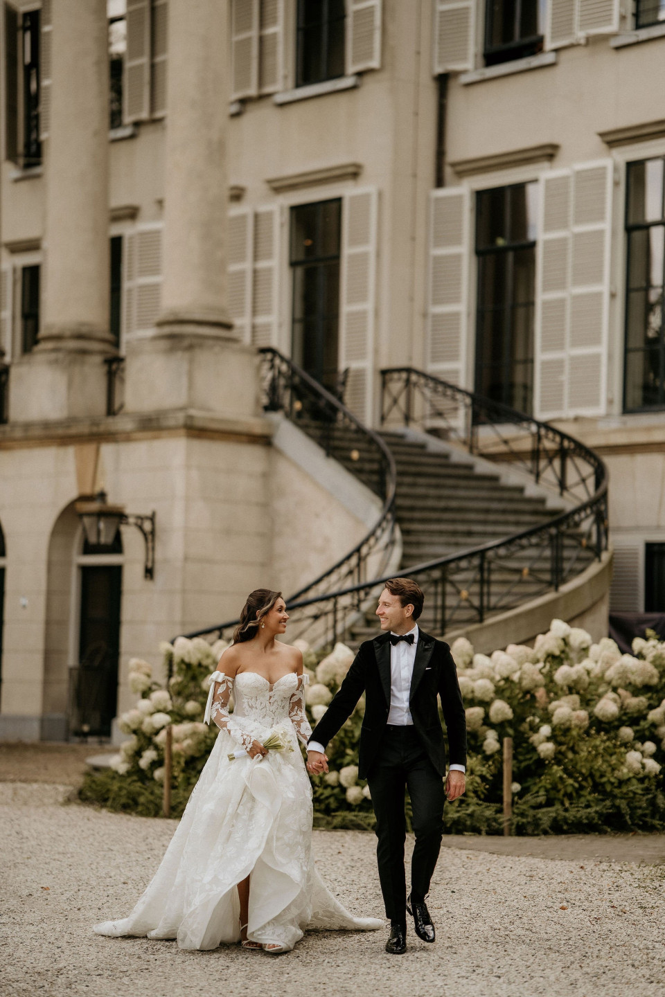 een bruid en bruidegom die voor een gebouw lopen