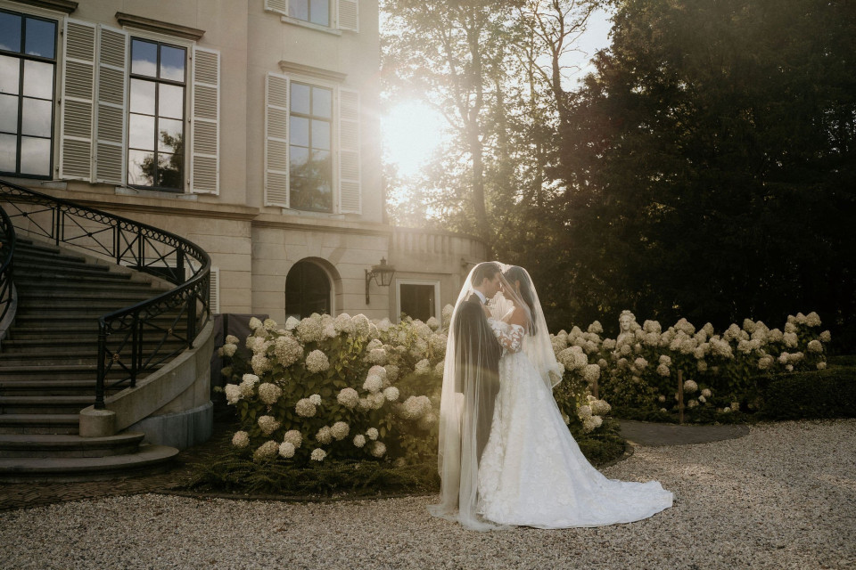 een bruid en bruidegom die voor een gebouw staan