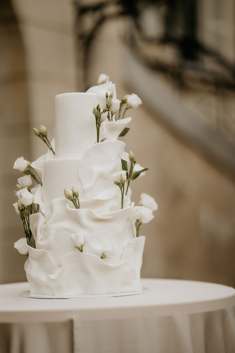 een close-up van een bruidstaart met witte bloemen