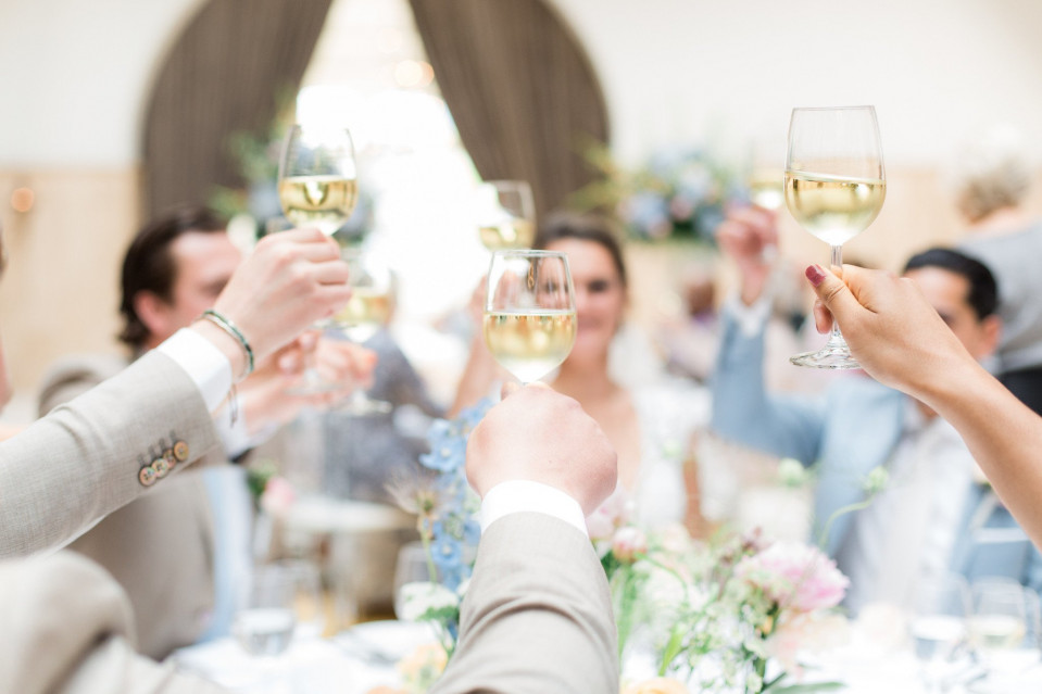een groep mensen toosten met wijnglazen