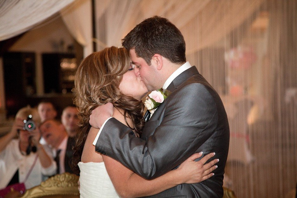 een bruid en bruidegom kussen tijdens hun eerste dans