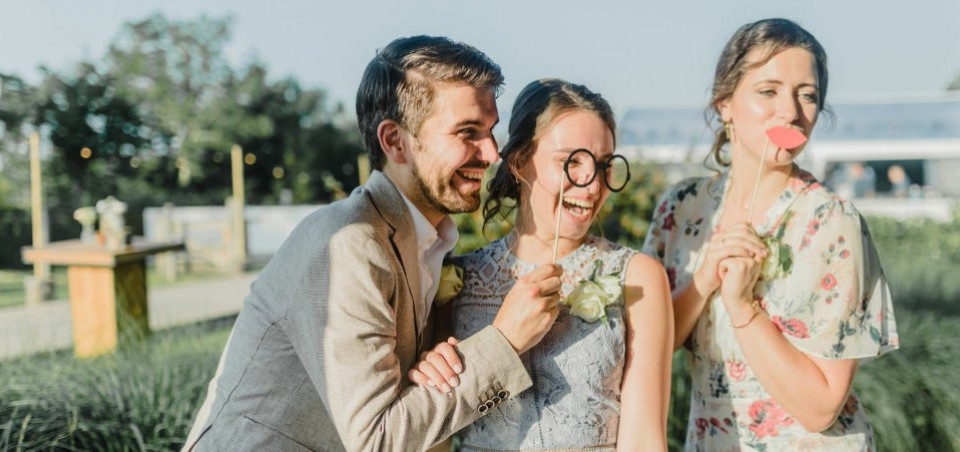 drie mensen poseren voor een foto met een bruidstaart