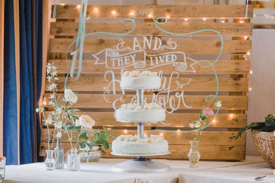 een trouwtaart staat op een houten tafel