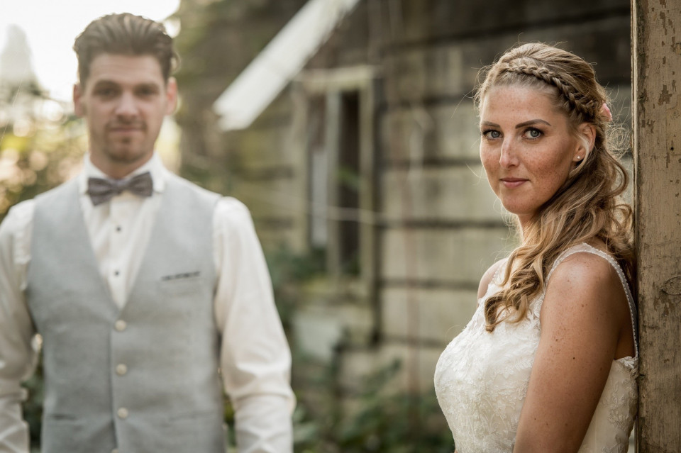 een bruid en bruidegom staan voor een oud gebouw