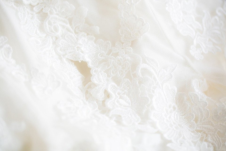 close-up van een trouwjurk met kant