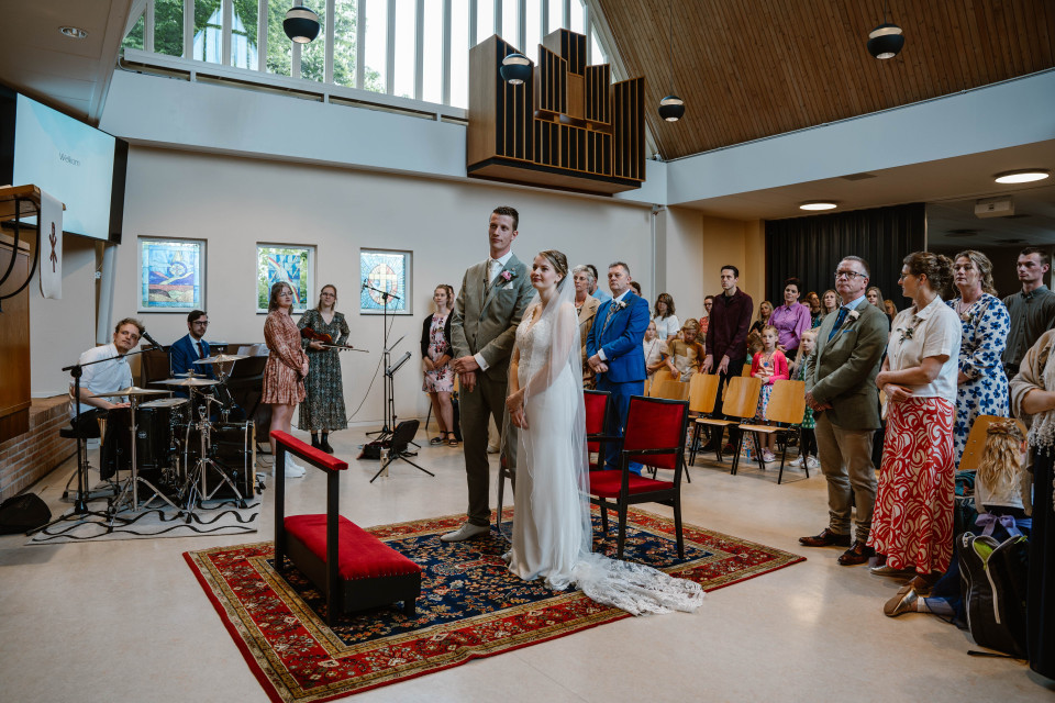 een huwelijksceremonie in een kerk met mensen die toekijken