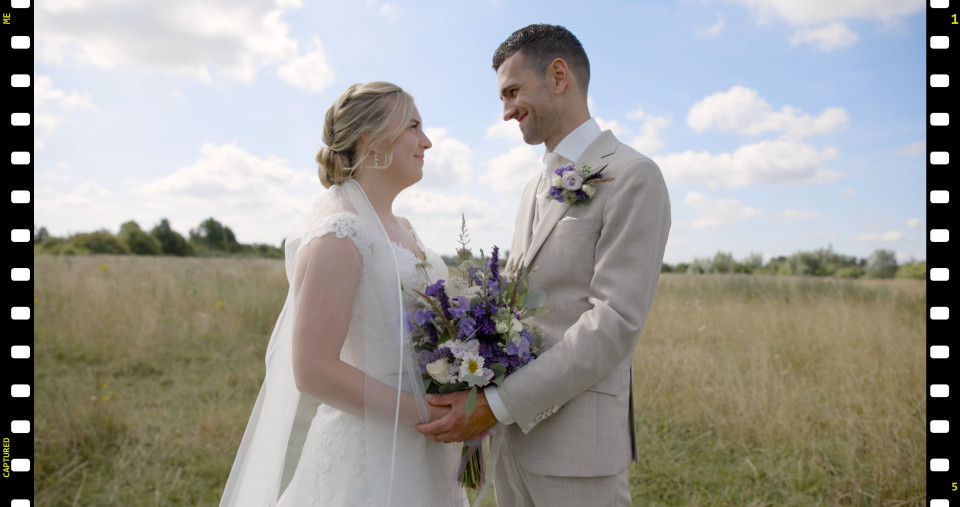 een bruid en bruidegom die samen in een veld staan