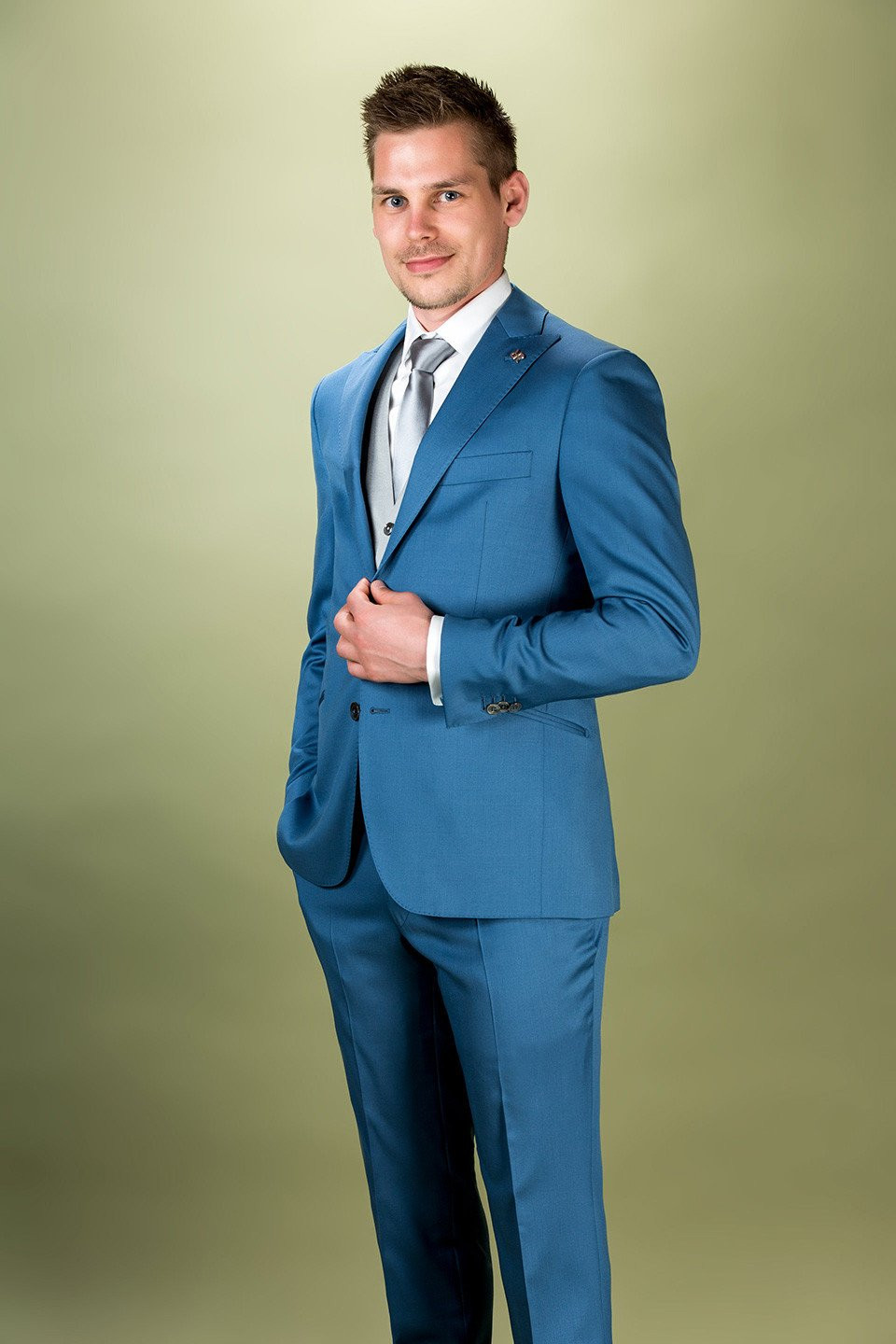 een man in een blauw pak poseert voor de camera