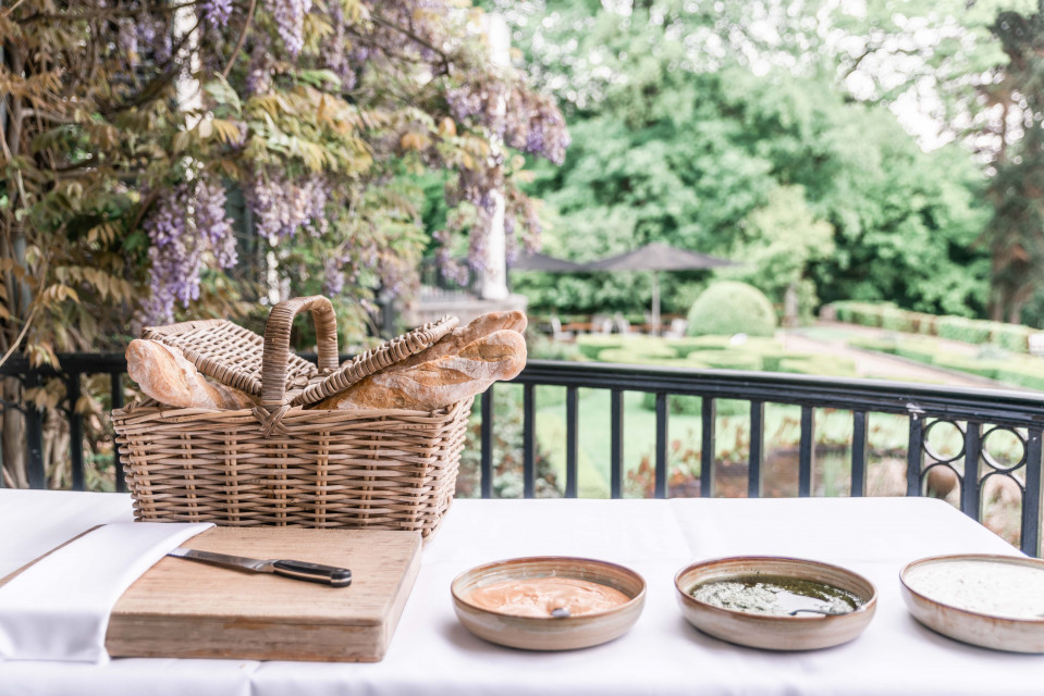 een tafel met brood, boter en ander eten erop
