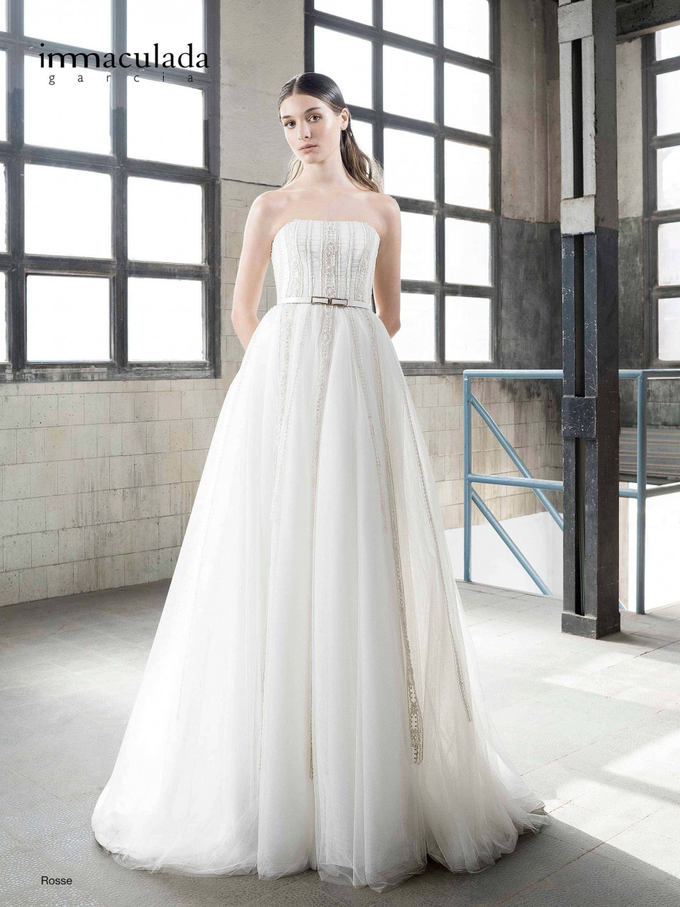 een vrouw in een trouwjurk staande in een lege kamer