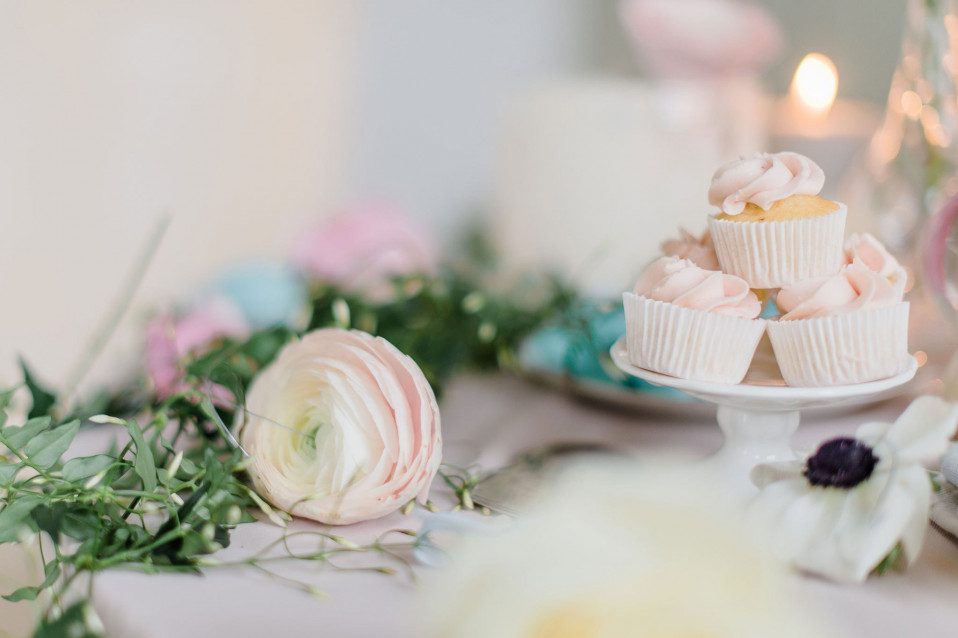een tafel met cupcakes en bloemen erop