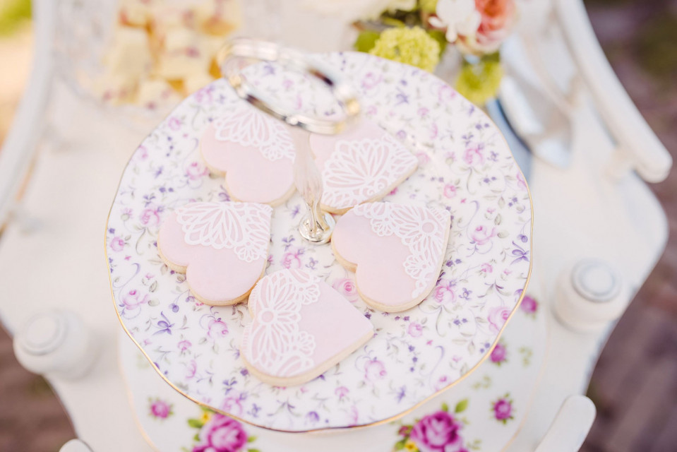 een witte tafel met roze en witte borden en een hartvormig koekje
