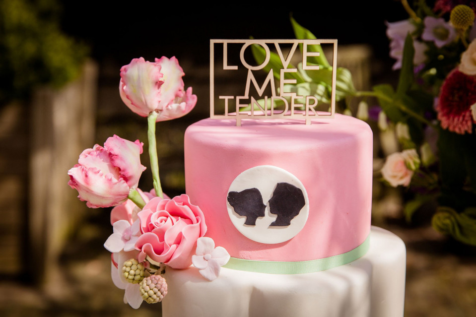 een roze taart met een zwart-witte beer erop