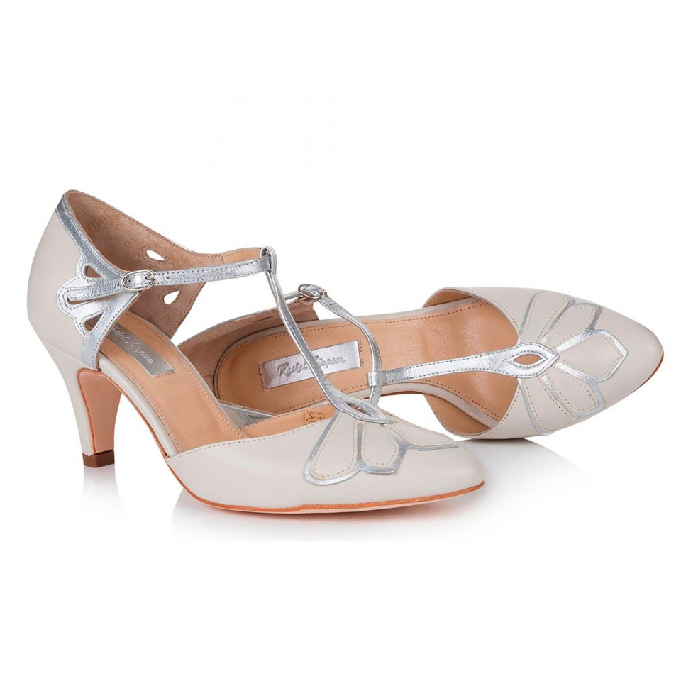 een paar witte hoge hak schoenen met zilveren bandjes