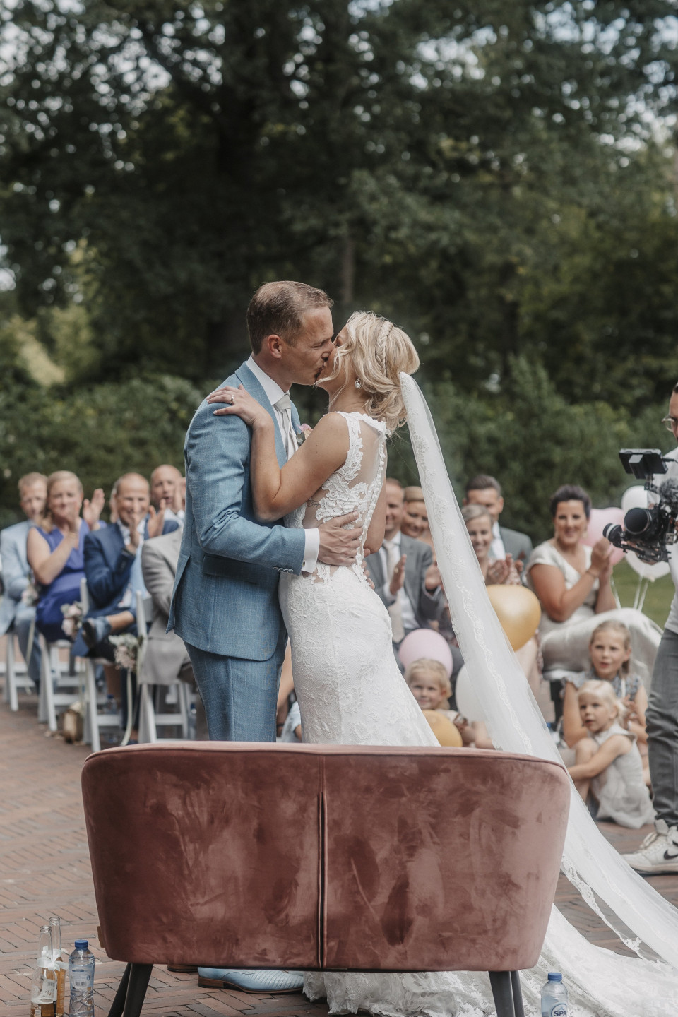 een bruid en bruidegom kussen voor hun gasten