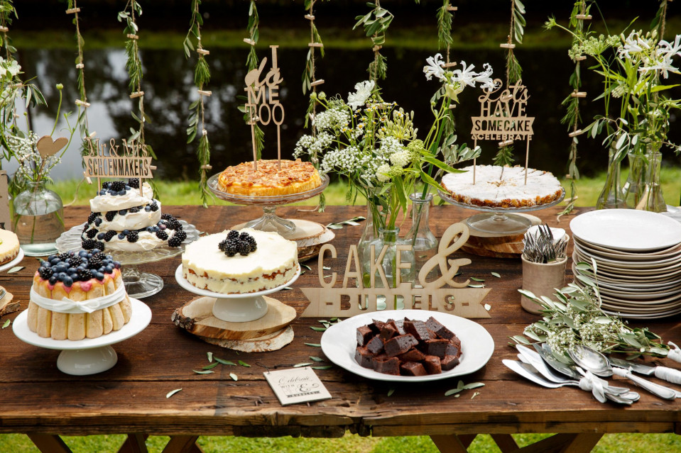 een rustieke trouwreceptietafel met taarten en desserts