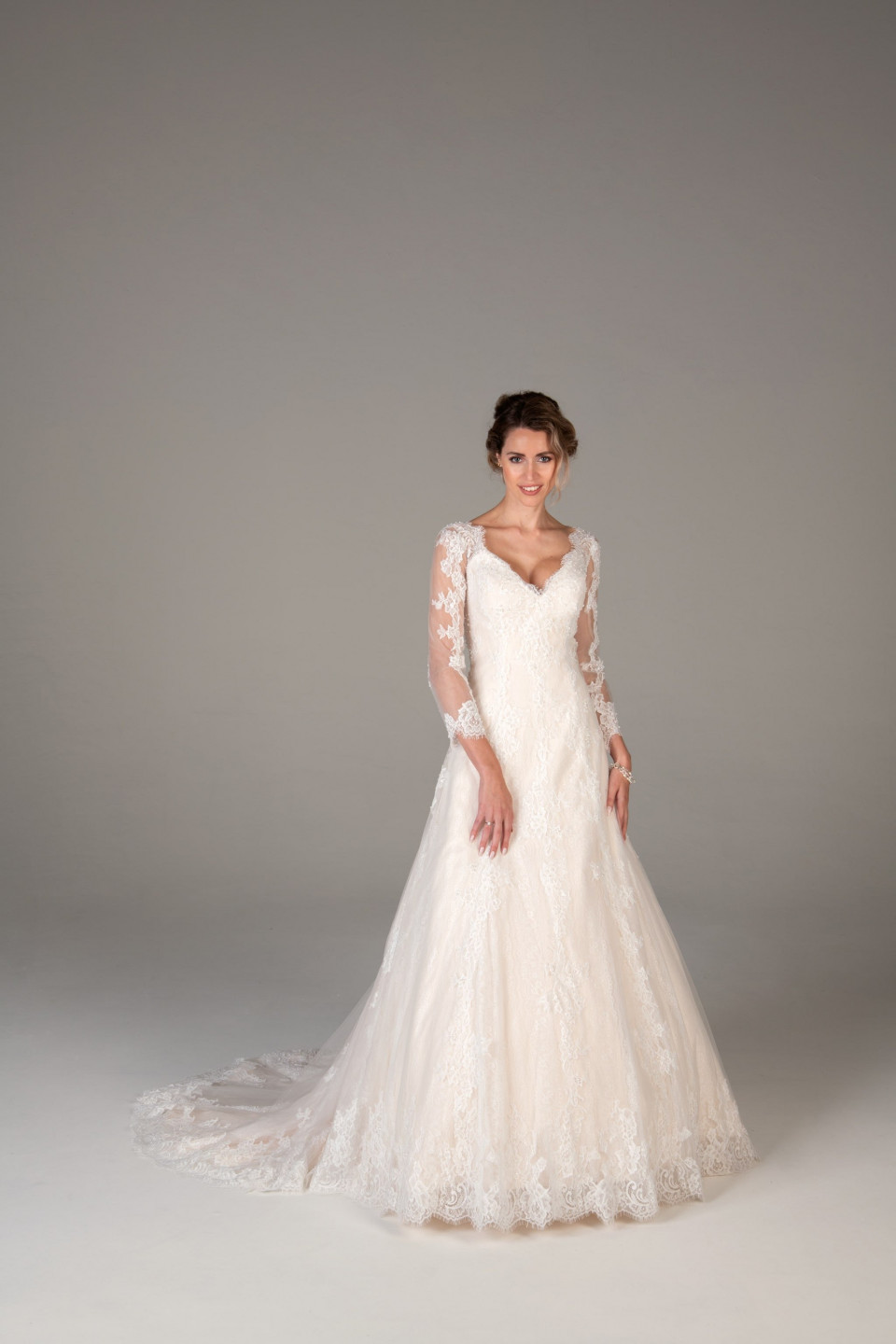 de bruid draagt een lange mouwen bruidsjurk met kant en tule