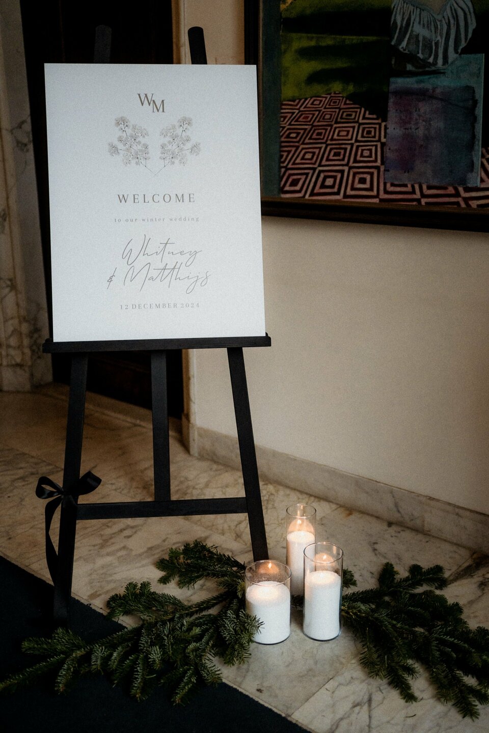 een welkomstbord met kaarsen ervoor