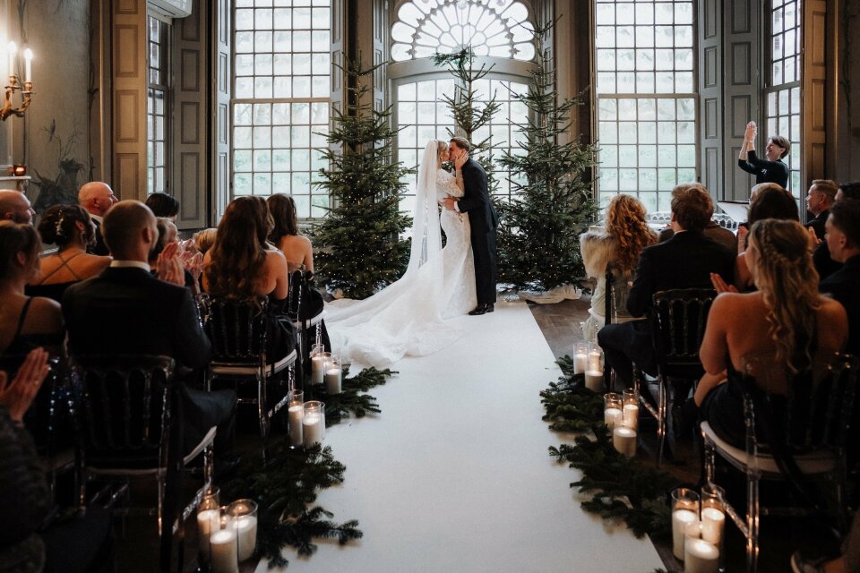 een bruid en bruidegom die voor een kerstboom staan