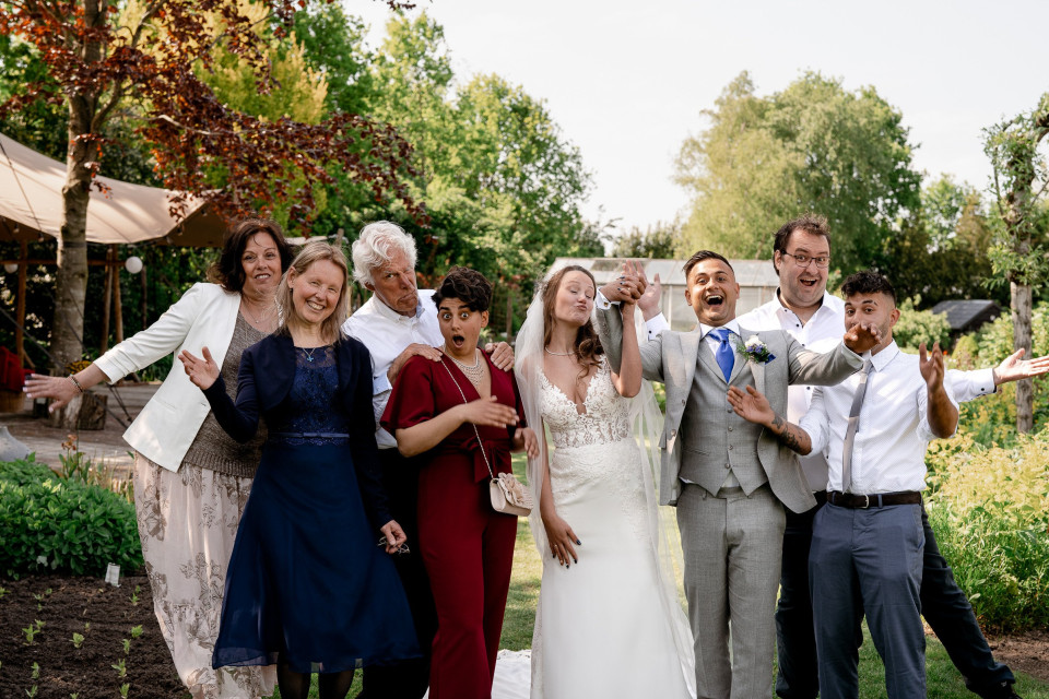 een groep mensen poseren voor een foto in een tuin