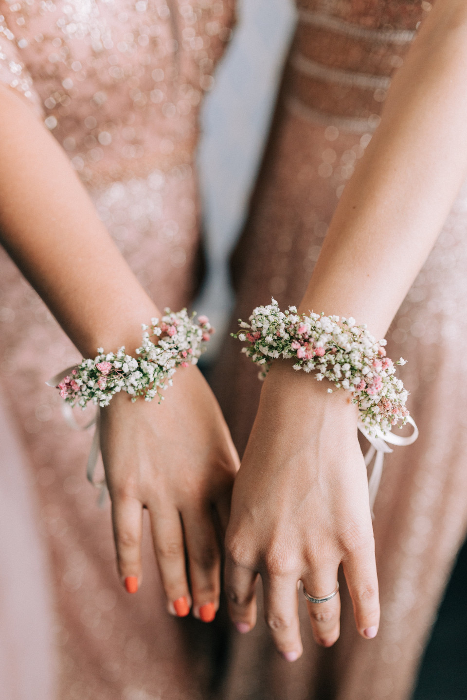 twee bruidsmeisjes die bloemenarmbanden dragen
