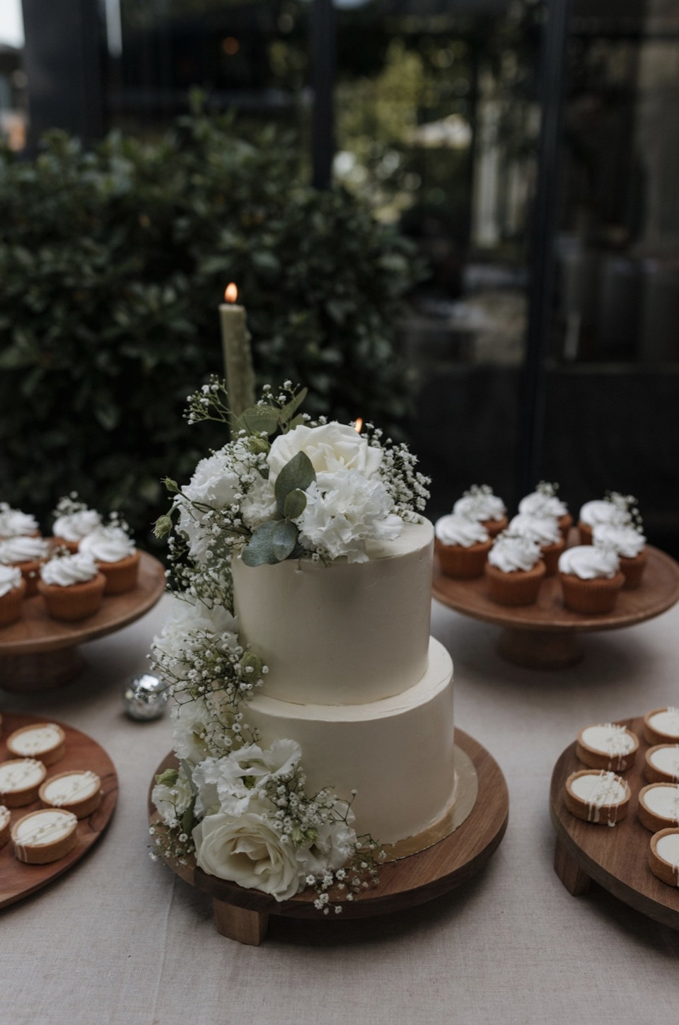 een bruidstaart en cupcakes op een tafel