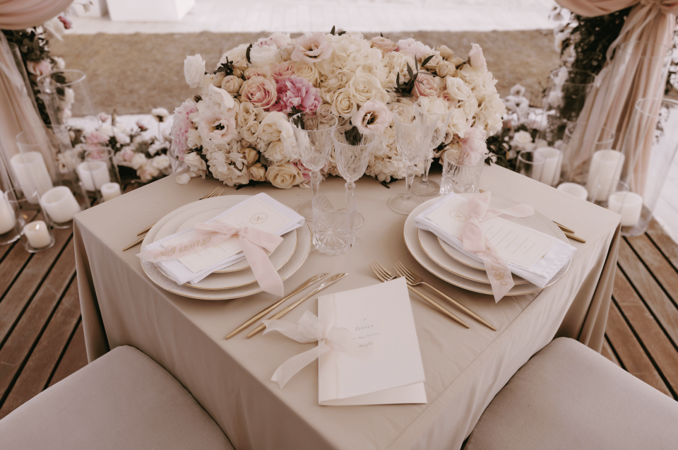 een tafelsetting met roze bloemen en witte servetten