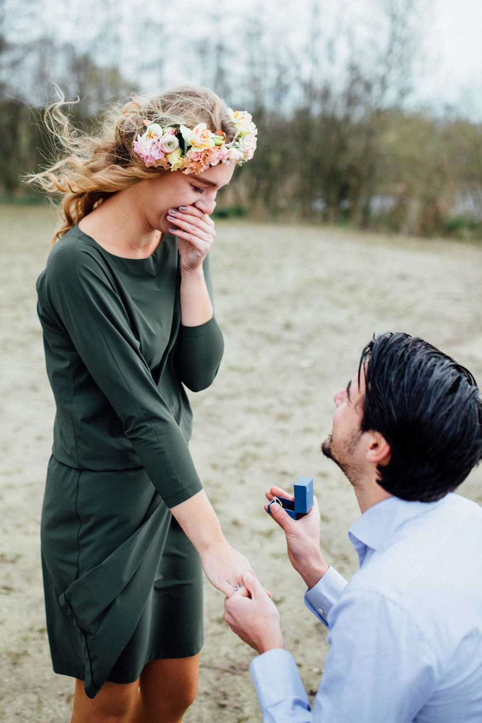 een man die zijn vriendin ten huwelijk vraagt op het veld