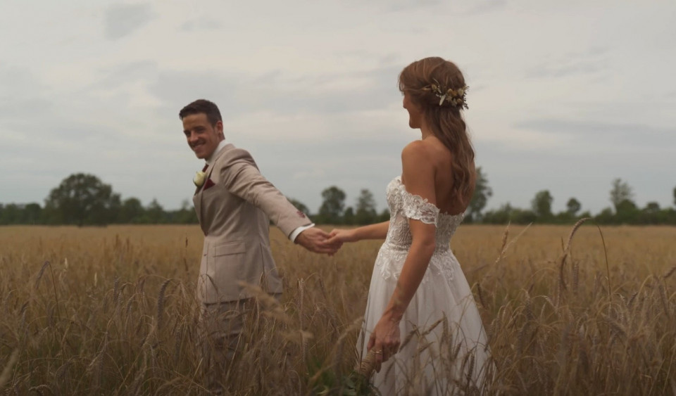 een pasgetrouwd stel loopt door een veld