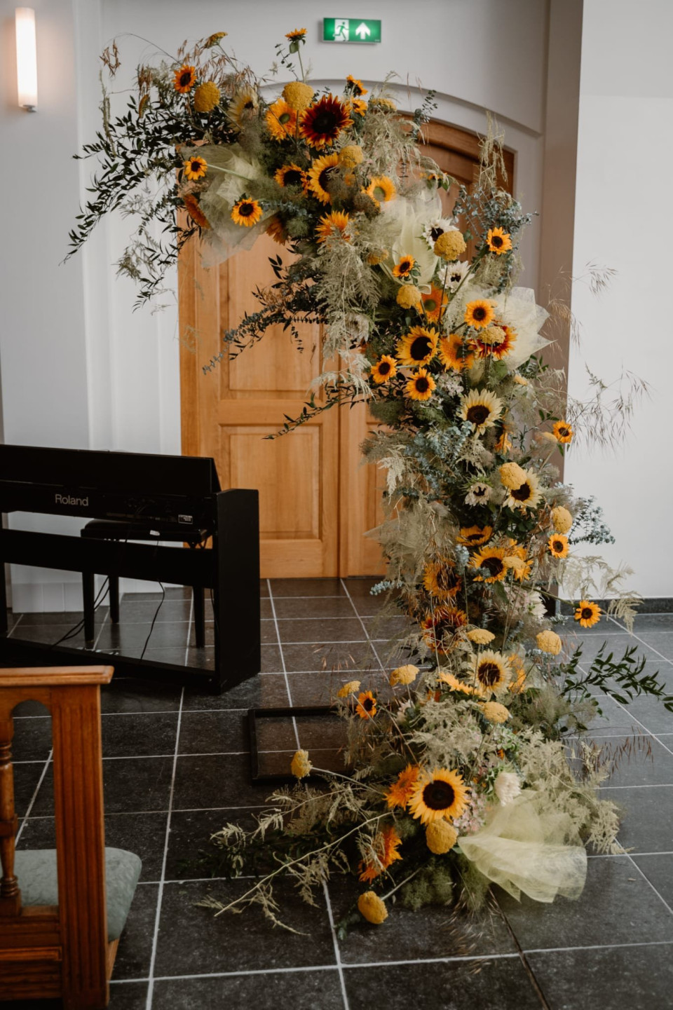 een trouwboog met zonnebloemen en groen