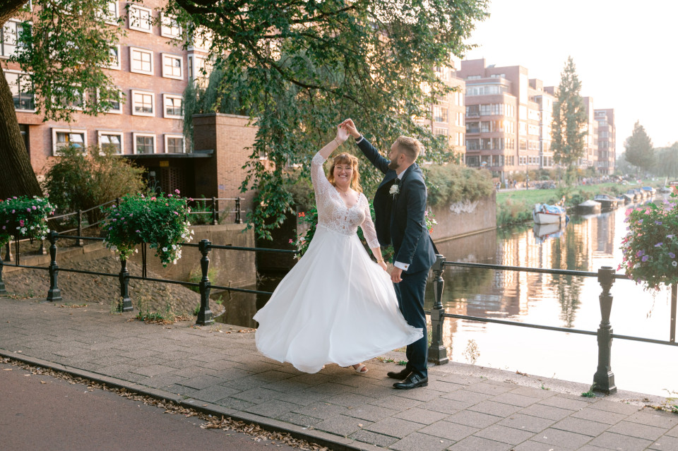 een bruid en bruidegom die dansen op de brug in Amsterdam