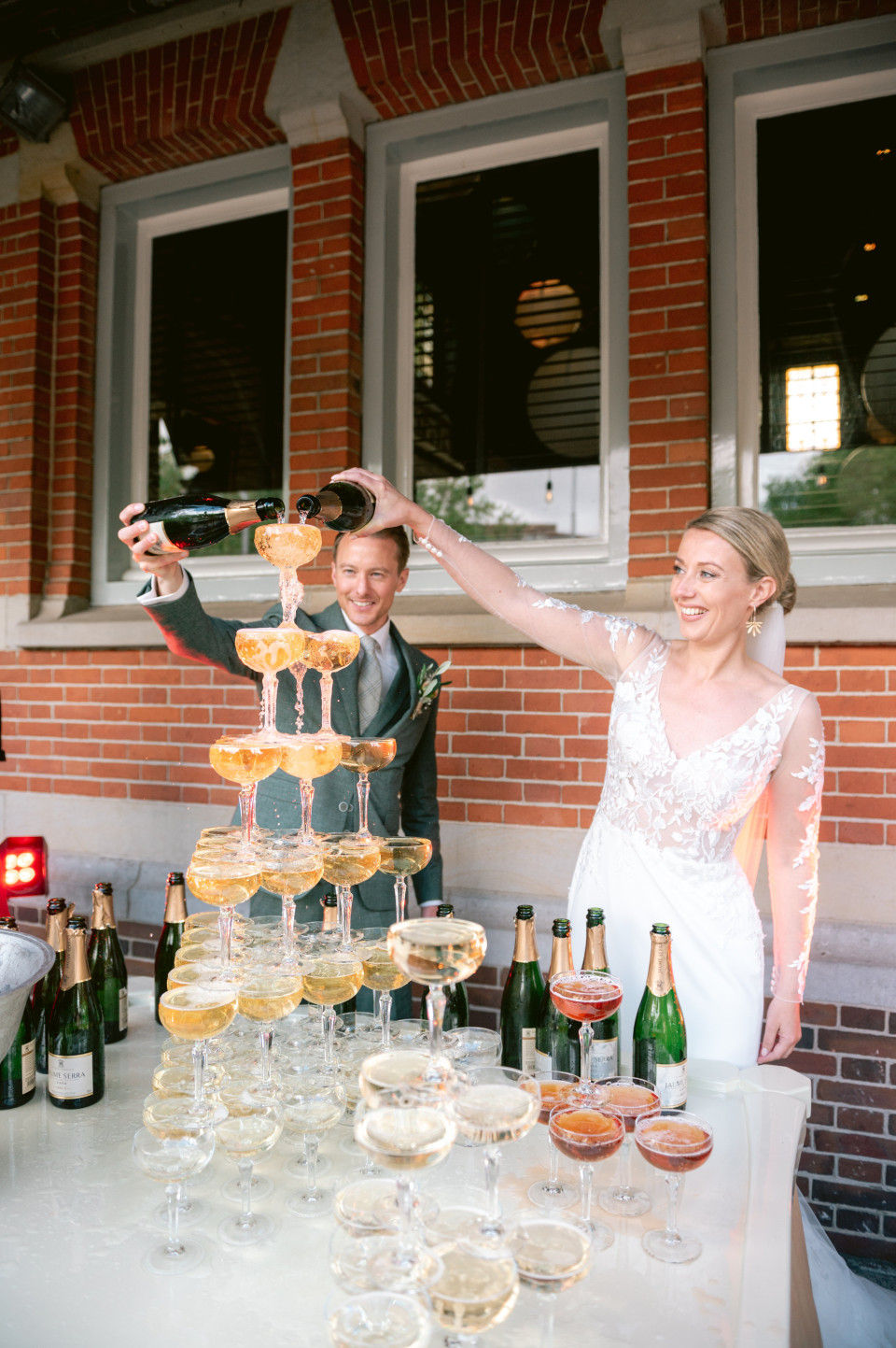 een bruid en bruidegom schenken champagne in glazen