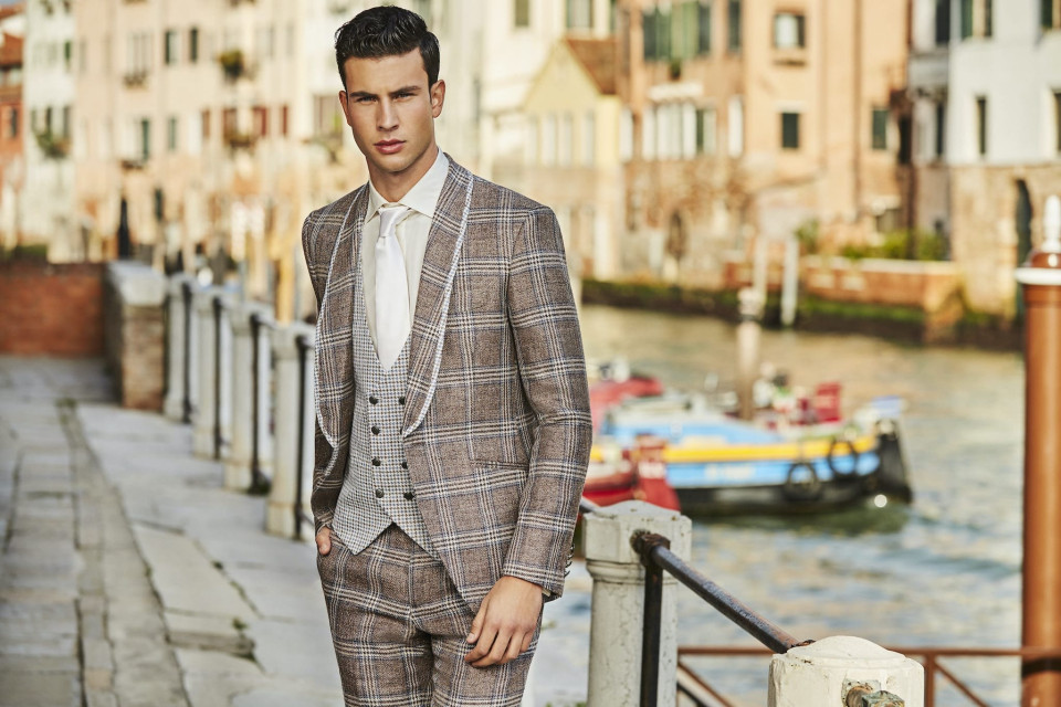 een man in een pak staat op een brug