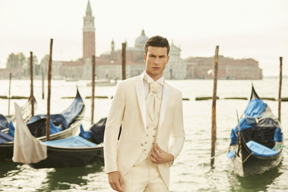 een man in een wit pak staat naast een boot