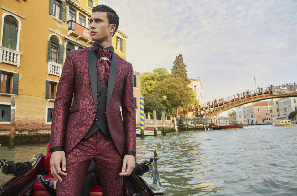 een man in een rood pak en strik op een gondel