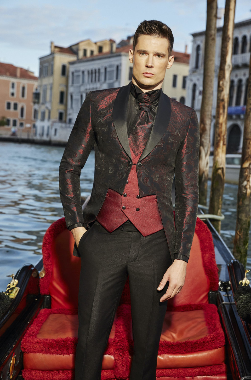 een man in een rood en zwart pak zit op een boot